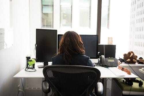 Woman developer at a desk with monitors.